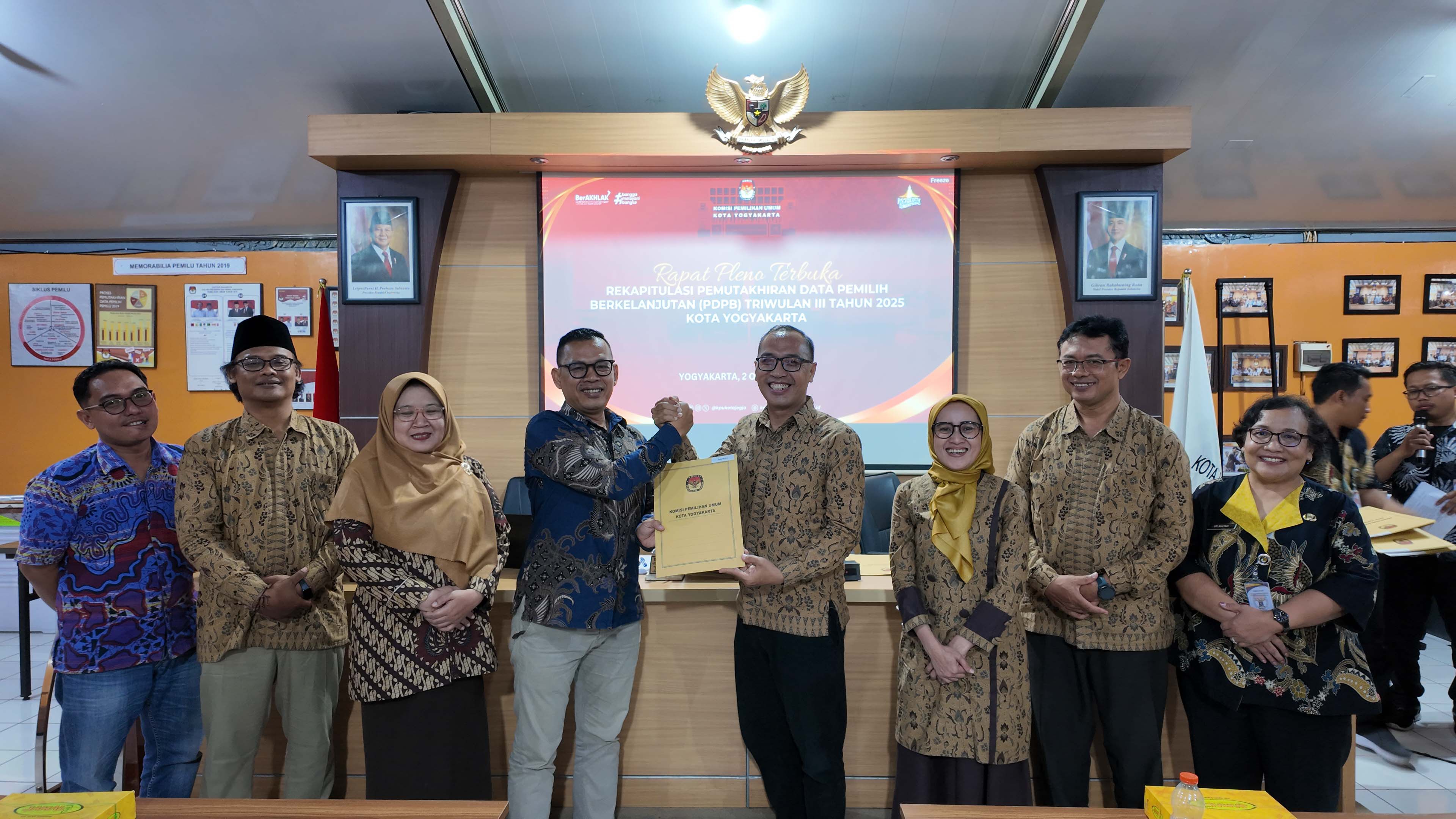 Ketua Bawaslu Kota Yogyakarta menerima salinan Berita Acara Rekapitulasi Daftar Pemilih Berkelanjutan Triwulan III Tahun 2025 dari Ketua KPU Kota Yogyakarta