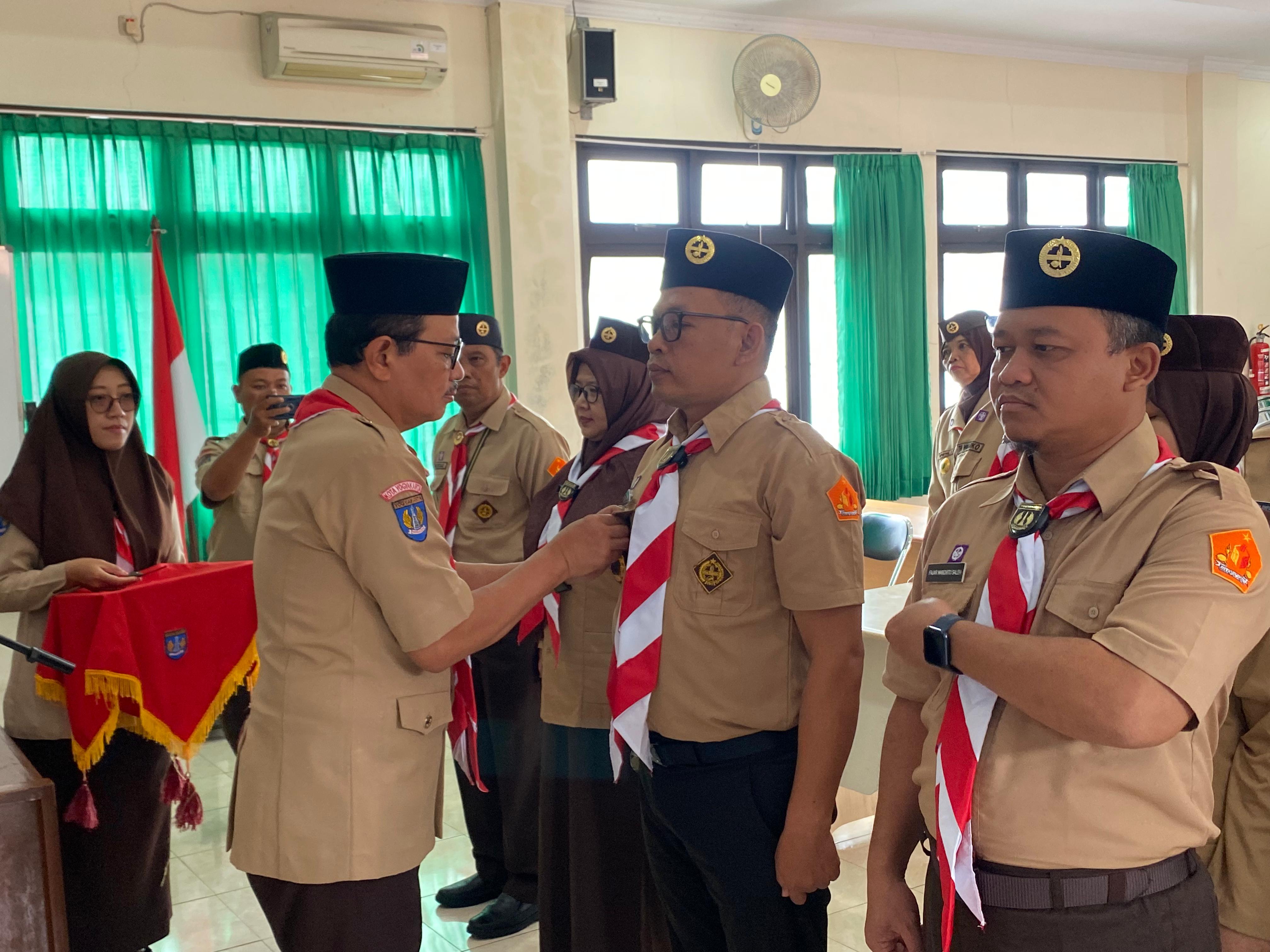 Ketua Kwarcab Gerakan Pramuka Kota Yogyakarta, Heroe Poerwadi, menyematkan tanjab kepada Ketua Bawaslu Kota Yogyakarta, Andie Kartala