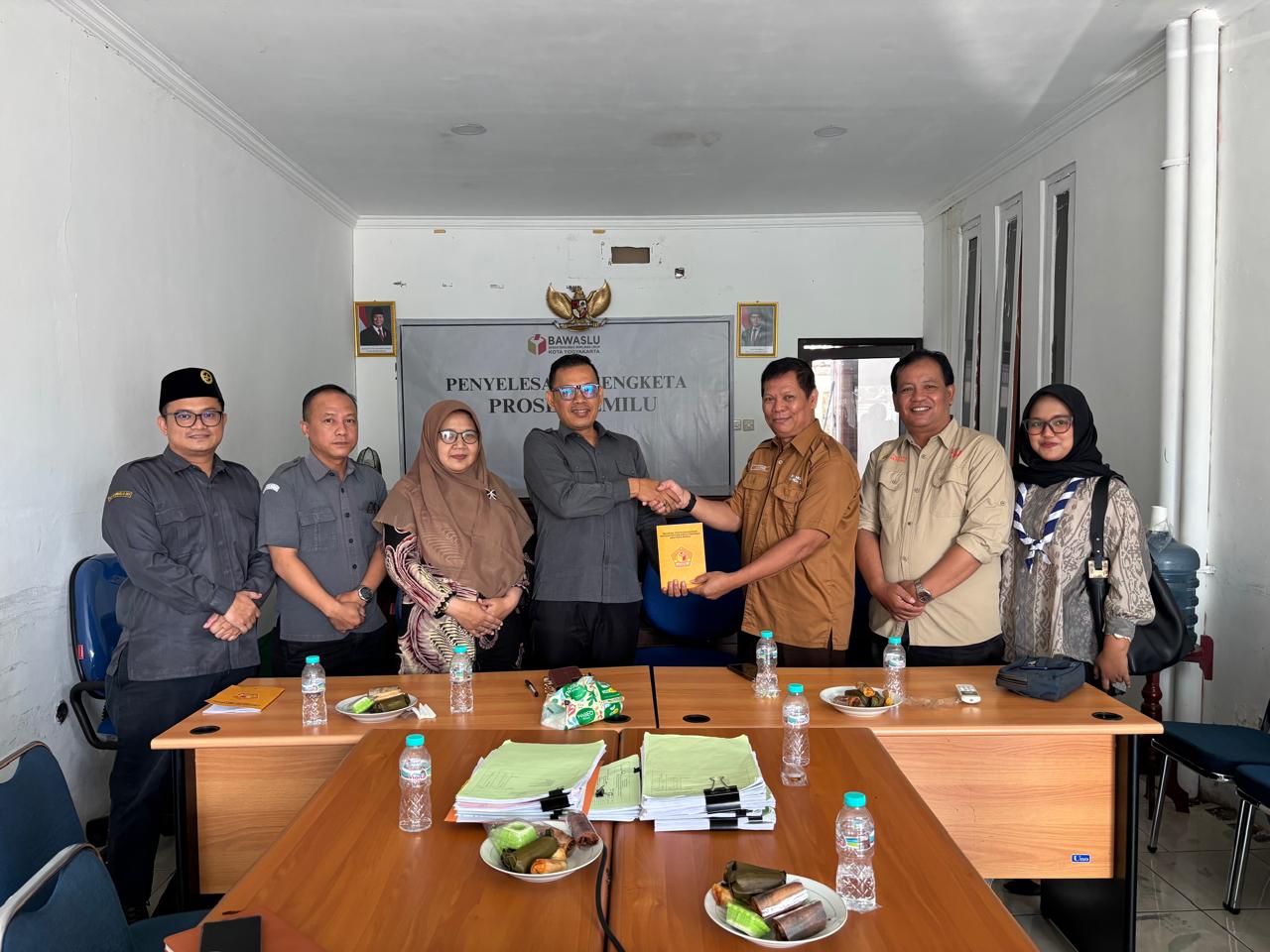 Ketua Bawaslu Kota Yogyakarta menerima Buku Pedoman Pembentukan Saka Adhyasta Pemilu dari perwakilan Kwarda DIY