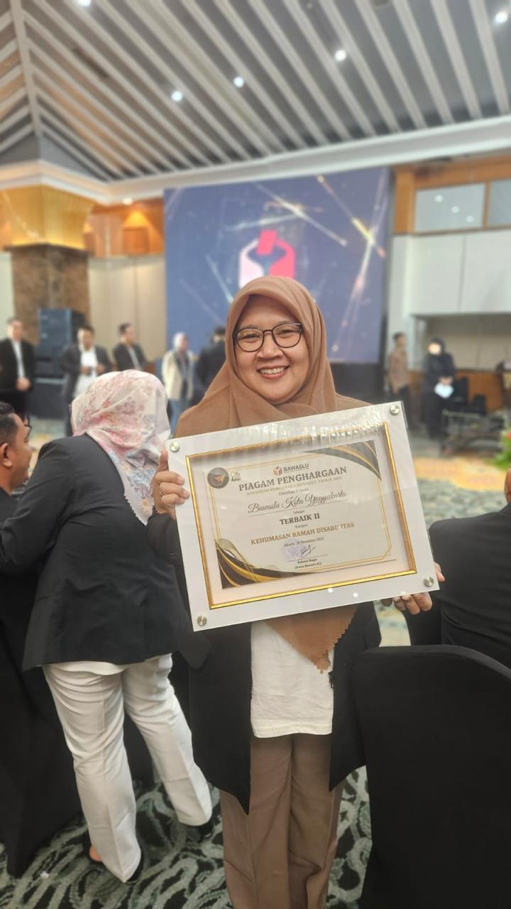 Anggota Bawaslu Kota Yogyakarta menunjukkan piagam penghargaan Terbaik II Kategori Kehumasan Ramah Disabilitas yang diberikan pada acara Anugerah Kehumasan Bawaslu Tahun 2025