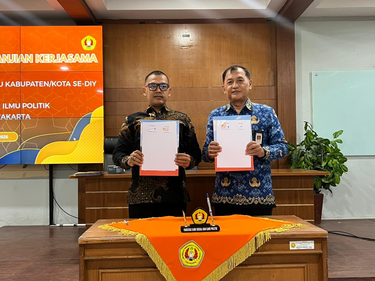 Ketua Bawaslu Kota Yogyakarta dan Dekan FISIP UPN Veteran Yogyakarta menunjukkan perjanjian kerja sama yang baru saja ditandatangani
